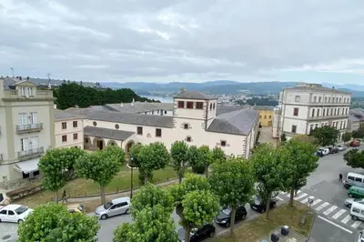 a city with cars parked in a parking lot at Ribadeo Cantábrico Yporá Deptos in Ribadeo