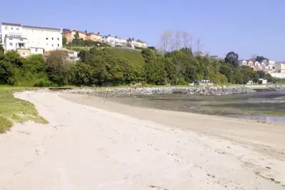 a sandy beach with buildings in the background at Ribadeo Cantábrico Yporá Deptos in Ribadeo