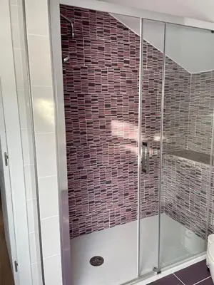 a shower with glass doors in a bathroom at Alojamientos con encanto Ruliña in Portomarin