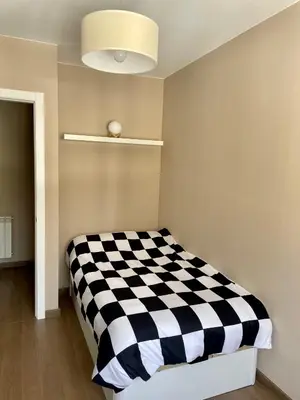 a bedroom with a black and white checkered bed at Alojamientos con encanto Ruliña in Portomarin
