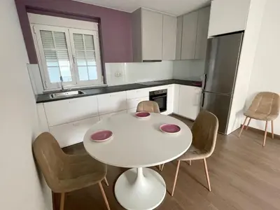a small kitchen with a white table and chairs at Alojamientos con encanto Ruliña in Portomarin