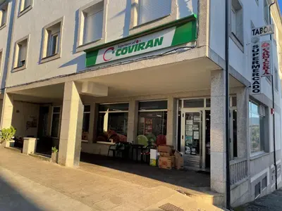 a store with a sign on the front of a building at Alojamientos con encanto Ruliña in Portomarin