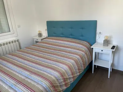 a bed with a blue headboard and a side table at Alojamientos con encanto Ruliña in Portomarin