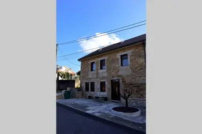 a stone house with a tree in front of it at Apartamento CATA Santiago de Compostela in Santiago de Compostela