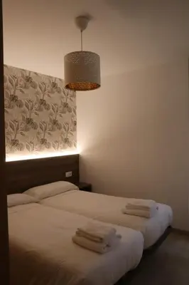 two beds in a room with towels on them at Apartamento CATA Santiago de Compostela in Santiago de Compostela