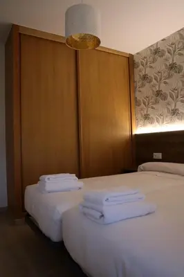 two beds with white towels on them in a room at Apartamento CATA Santiago de Compostela in Santiago de Compostela