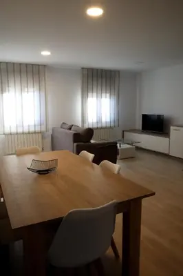 a living room with a wooden table and chairs at Apartamento CATA Santiago de Compostela in Santiago de Compostela
