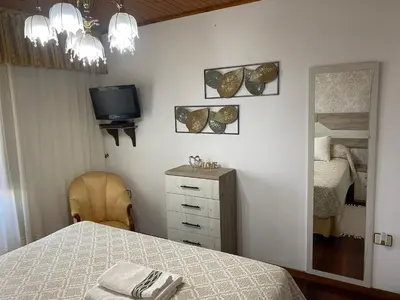 a bedroom with a bed and a tv and a mirror at Casa De Cacheiro in Silleda