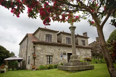 an old stone house with a pole in front of it at Casa De Cacheiro in Silleda