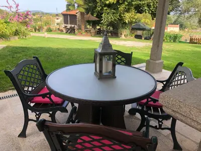 a table with four chairs and a lamp on it at Casa De Cacheiro in Silleda