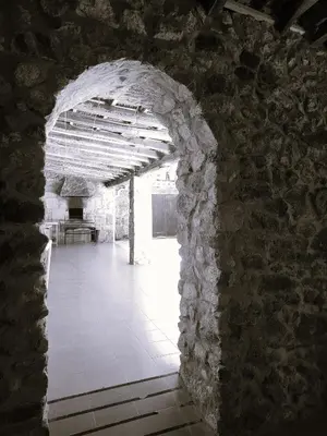 an archway in a stone building with a table in the background at Alojamiento Pena da Osa in Sober