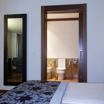a bedroom with a bed and a bathroom with a toilet at Hotel Palacio de Merás in Tineo