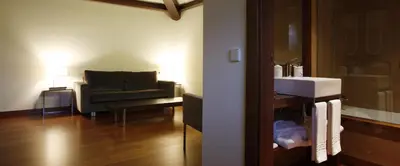 a bathroom with a sink and a couch in a room at Hotel Palacio de Merás in Tineo