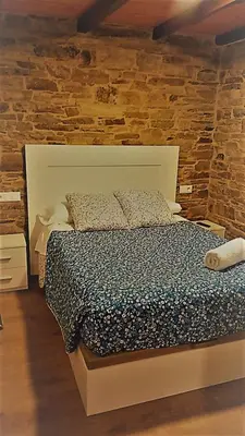 a bed in a room with a brick wall at Apartamentos Fons sacrata in Fonsagrada