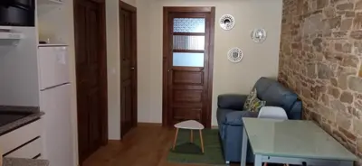 a living room with a blue couch and a table at Apartamentos Fons sacrata in Fonsagrada