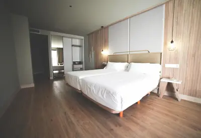 a bedroom with a large white bed and wooden floors at IMI Hotel & Spa in Ourense