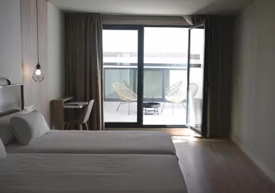 a bedroom with a bed and a view of a patio at IMI Hotel & Spa in Ourense