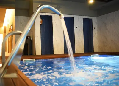 a swimming pool with a water fountain in a building at IMI Hotel & Spa in Ourense