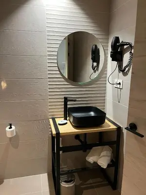 a bathroom with a sink and a mirror at IMI Hotel & Spa in Ourense