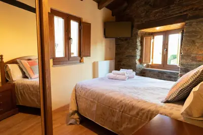 a bedroom with a bed with two towels on it at As Veneiras Casa in Neipín