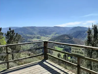 a wooden boardwalk with a sign on top of a mountain at As Veneiras Casa in Neipín