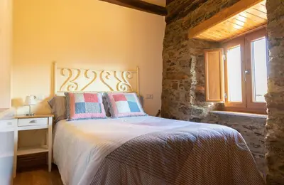 a bedroom with a bed and a window at As Veneiras Casa in Neipín