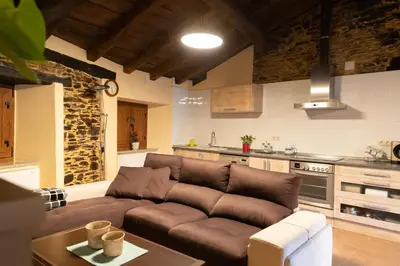 a living room with a brown couch in a kitchen at As Veneiras Casa in Neipín