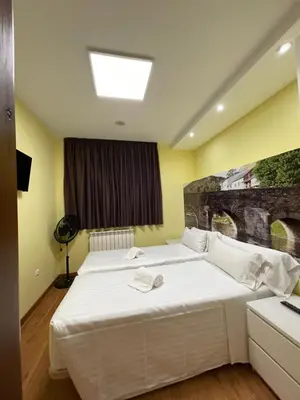 a bedroom with two beds and a window at The Way Hotel Molinaseca in Molinaseca
