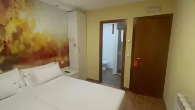 a bedroom with a white bed and a bathroom at The Way Hotel Molinaseca in Molinaseca
