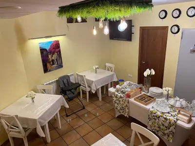 a room with two tables and chairs and clocks on the wall at The Way Hotel Molinaseca in Molinaseca