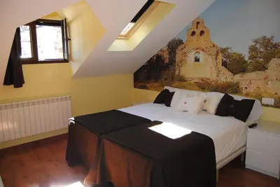a bedroom with a bed with a painting on the wall at The Way Hotel Molinaseca in Molinaseca