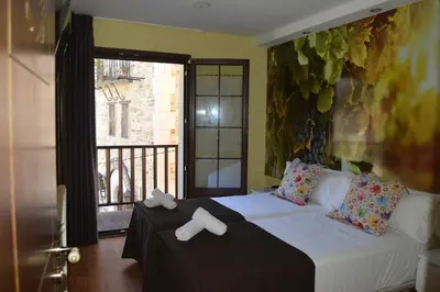 a bedroom with a white bed with a window at The Way Hotel Molinaseca in Molinaseca