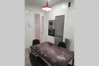 a kitchen with a table with chairs and a refrigerator at CONTRASTES RIBEIRA SACRA in Monforte de Lemos