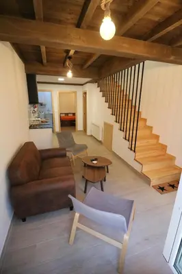 a living room with a couch and a table and stairs at Buen Camino Melide in Melide