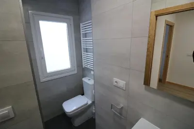 a bathroom with a toilet and a window and a mirror at Buen Camino Melide in Melide