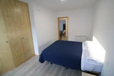 a bedroom with a blue bed and a wooden closet at Buen Camino Melide in Melide
