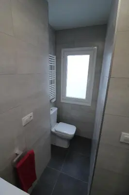 a bathroom with a toilet and a window at Buen Camino Melide in Melide