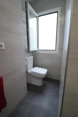 a bathroom with a toilet and a window at Buen Camino Melide in Melide
