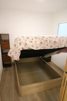 a bed with a floral sheet on top of it at Buen Camino Melide in Melide