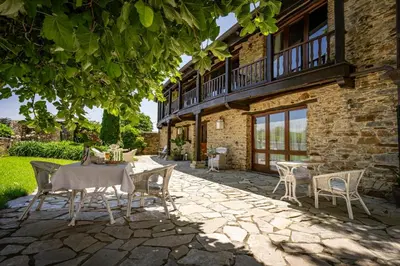 a patio with a table and chairs in front of a building at Casa Peleyón in Castropol