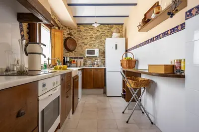 a kitchen with a white refrigerator and wooden cabinets at Casa Peleyón in Castropol