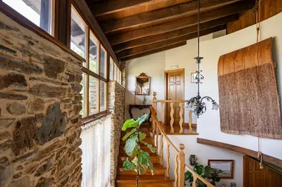 a staircase in a house with a stone wall at Casa Peleyón in Castropol