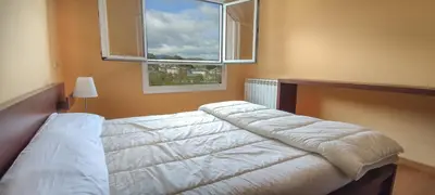 a bedroom with a white bed with a window at HOLIDAY HOMES by del abuelo VEGADEO in Vegadeo