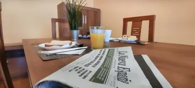 a book on a table with a glass of orange juice at HOLIDAY HOMES by del abuelo VEGADEO in Vegadeo