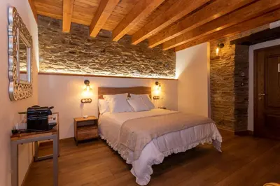 a bedroom with a bed and a stone wall at Araucaria House in Barreiros