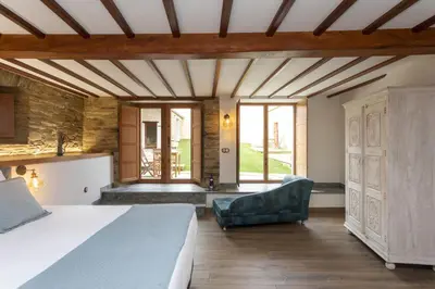 a bedroom with a bed and a couch and windows at Araucaria House in Barreiros