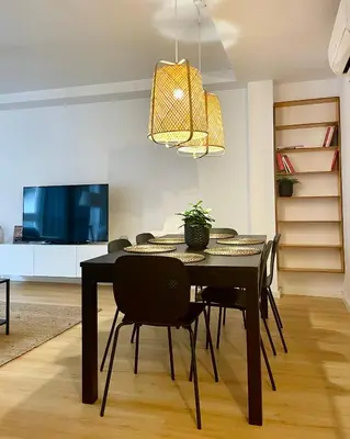 a dining room with a black table and chairs at Home Las Burgas D&C in Ourense