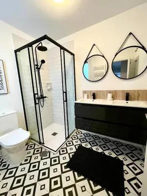 a bathroom with a shower and a toilet and two mirrors at Home Las Burgas D&C in Ourense