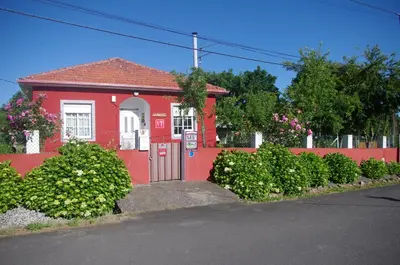 a red house with a red fence and bushes at CAMBOTE Vivienda turìstica in Lugo