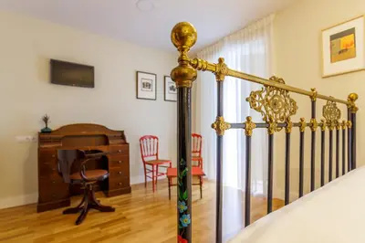 a bedroom with a bed and a desk and a chair at Hotel Casa da Galbana in Friol